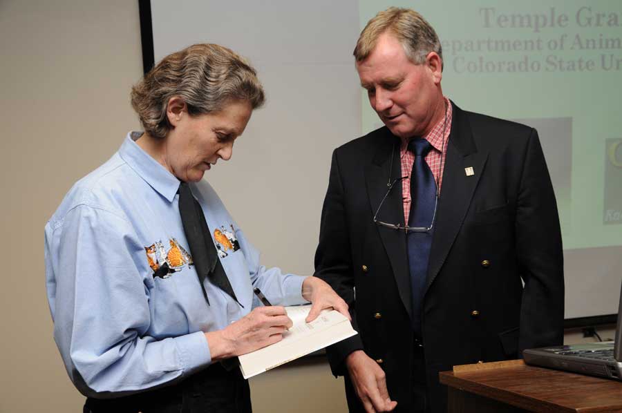 Dr. Temple Grandin (left), autographs a copy of her newest book for Dr. David Hodgson (right), head of the Department of Large Animal Clinical Sciences in the Virginia-Maryland Regional College of Veterinary Medicine at Virginia Tech.