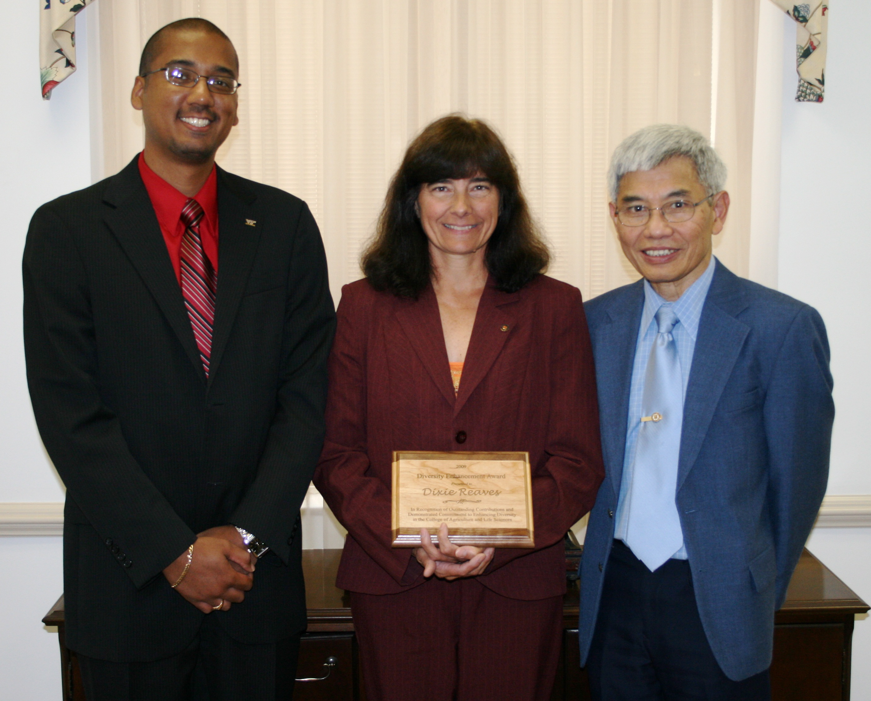 Ray Ali, associate director of field operations for the Virginia Cooperative Extension (left), and Loke T. Kok (right), interim dean of the College of Agriculture and Life Science, presents Dixie Watts Reaves the Diversity Enhancement Award.