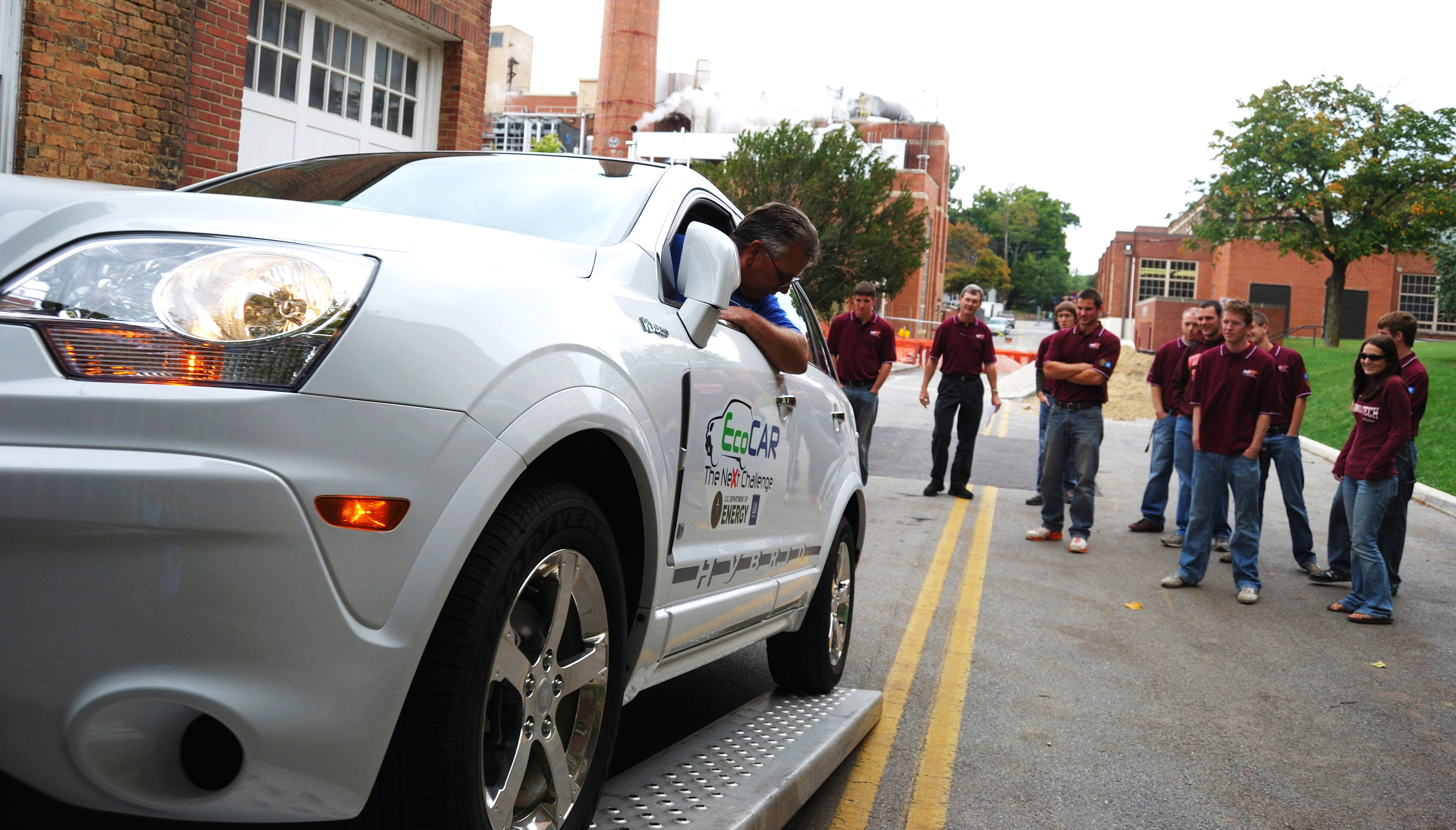 The 2009-10 Hybrid Electric Vehicle Team of Virginia Tech (HEVT) witness delivery of a 2009 crossover SUV donated by General Motors. As part of the EcoCAR Challenge, the team will re-engineer the car to use less fuel per mile and cut emissions. Among those in the background is Doug Nelson, a Virginia Tech professor of mechanical engineering the faculty adviser for the EcoCAR Challenge competition.