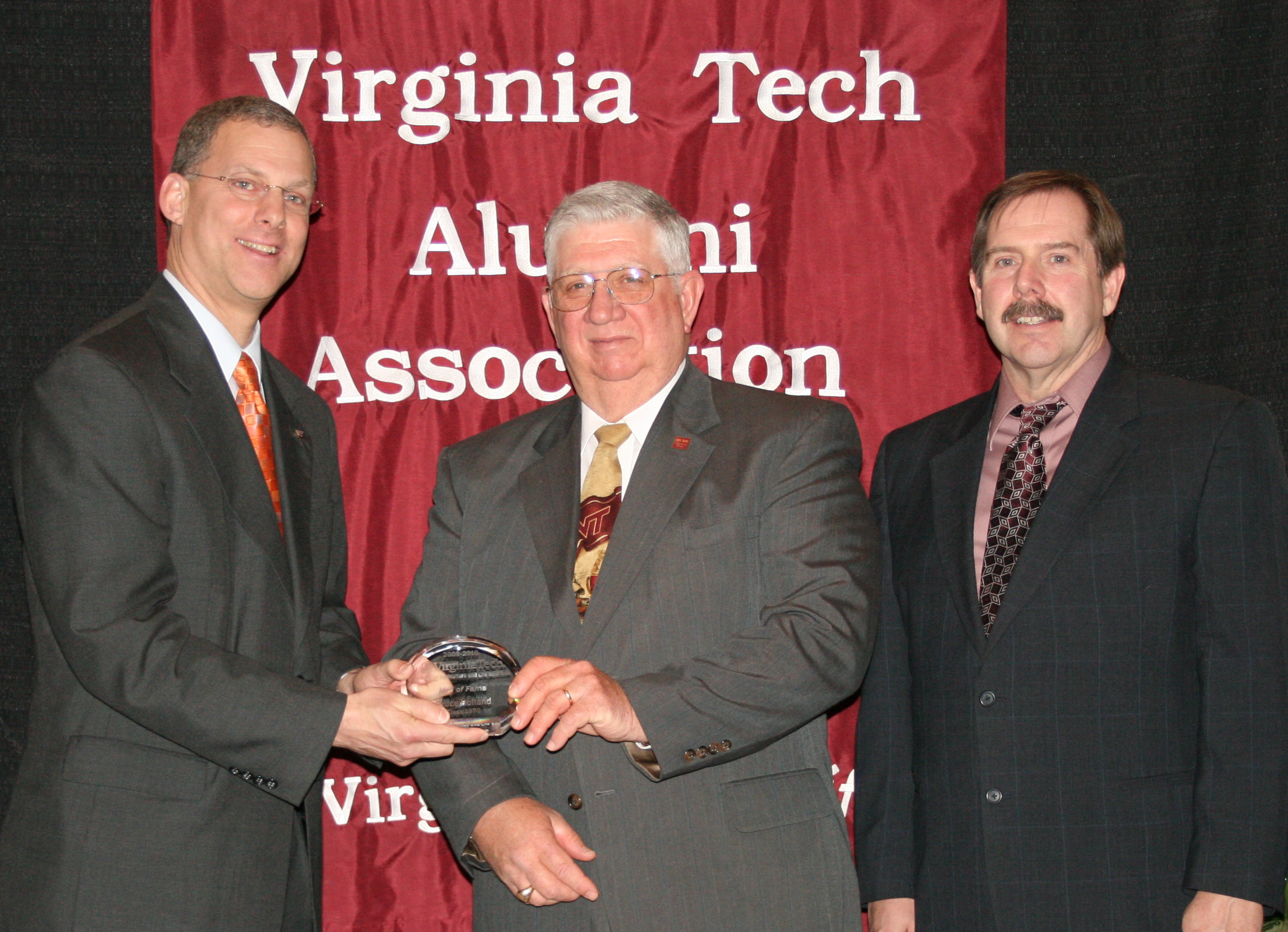 Bruce Holland (center) receives the Hall of Fame Award from Alan Grant (left), dean of the College of Agriculture and Life Sciences, and Kevin Boyle (right), professor and head of the Department of Agricultural and Applied Economics, at the annual Alumni Awards Program on March 5, 2010.