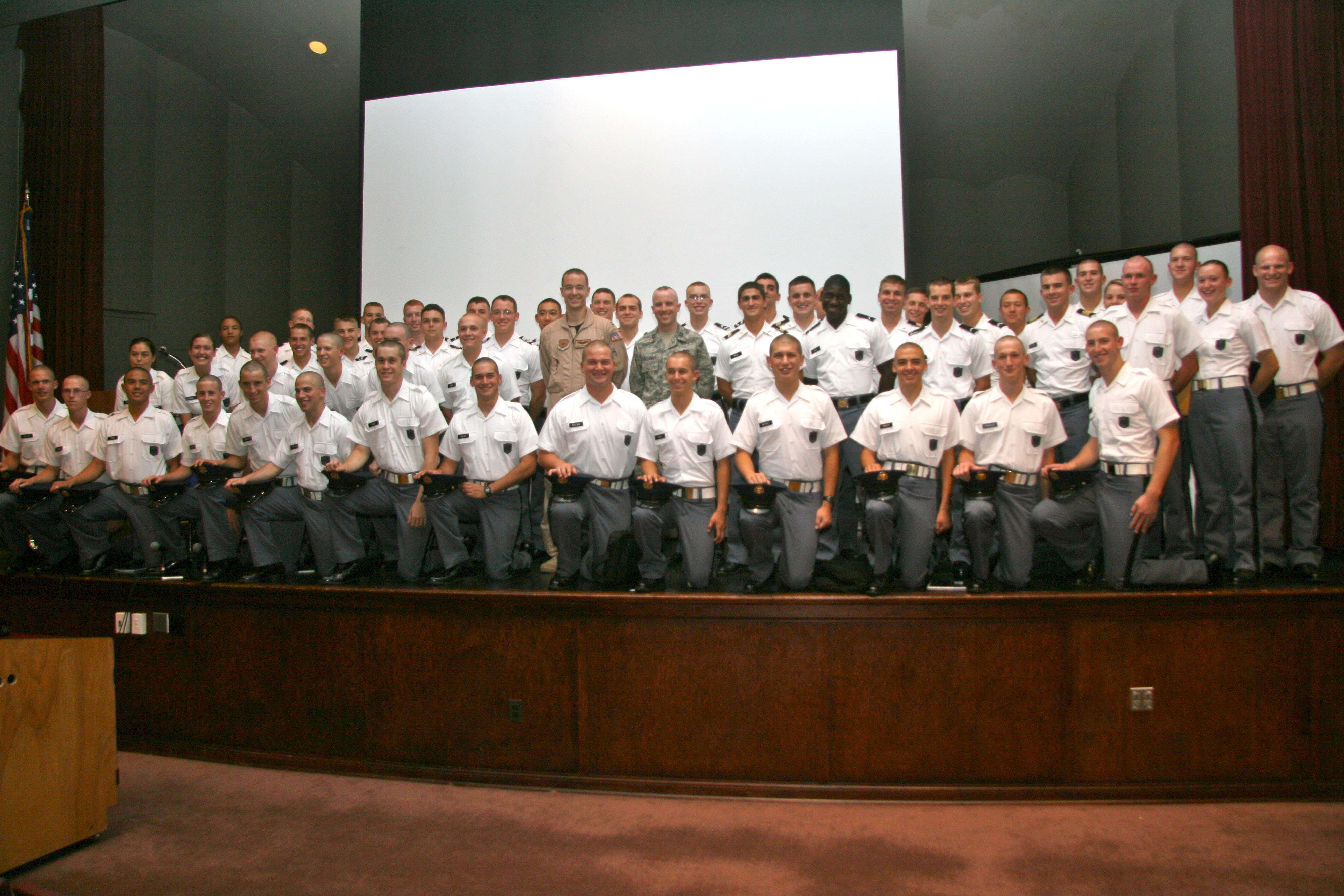 Capt. Dan Richardson (center, left), U.S. Air Force and Capt. Chris Callaway (center, right), U.S. Air Force, previous Gunfighter panelists standing on stage with members of their former cadet company. Echo Company