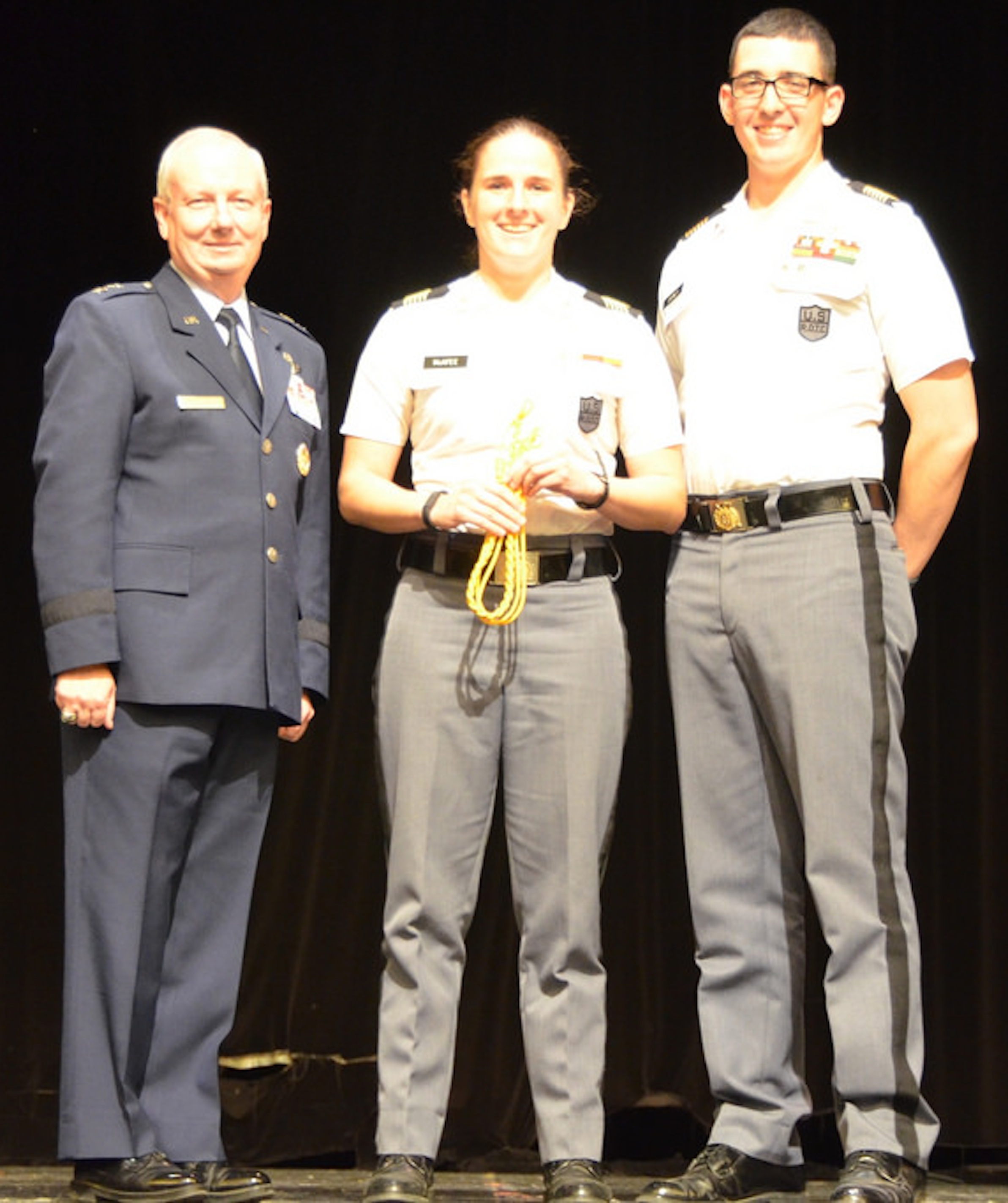 Cadet Rebecca McAfee, center, Hotel Company commander, accepts the Gold Cord from the Commandant of Cadets Maj. Gen. Randal Fullhart, left, and the Regimental Commander Cadet Jordan Disney, right.