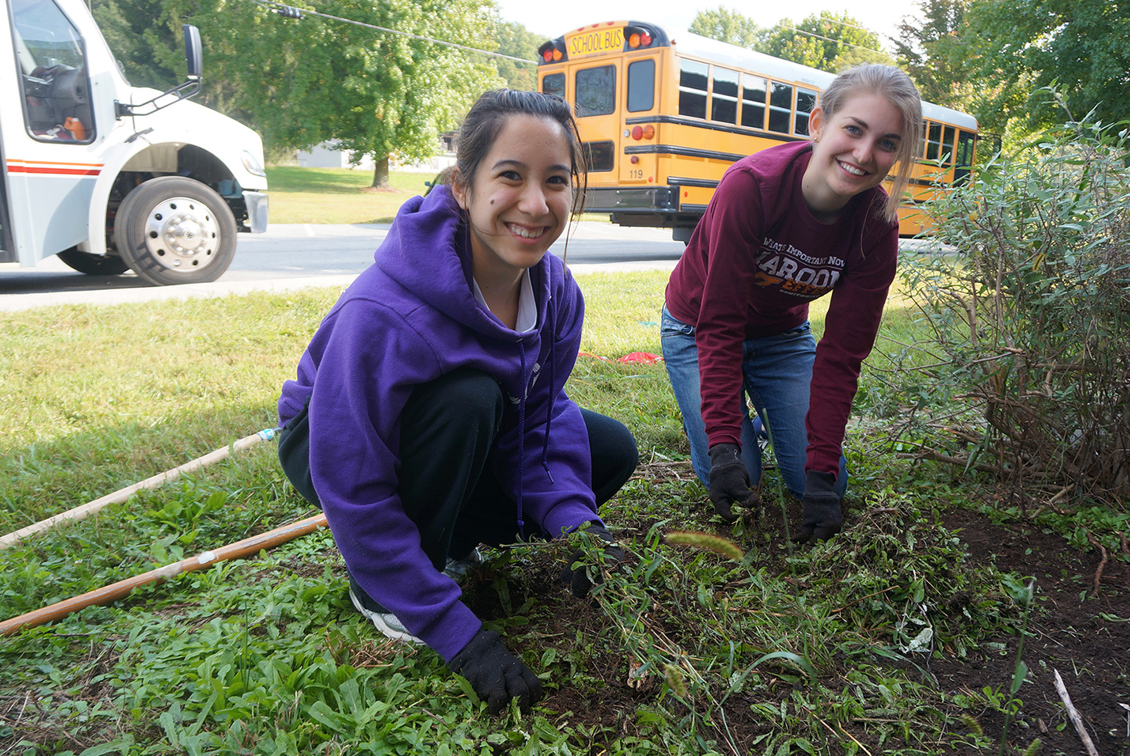Two students perform landscaping at an elementary school