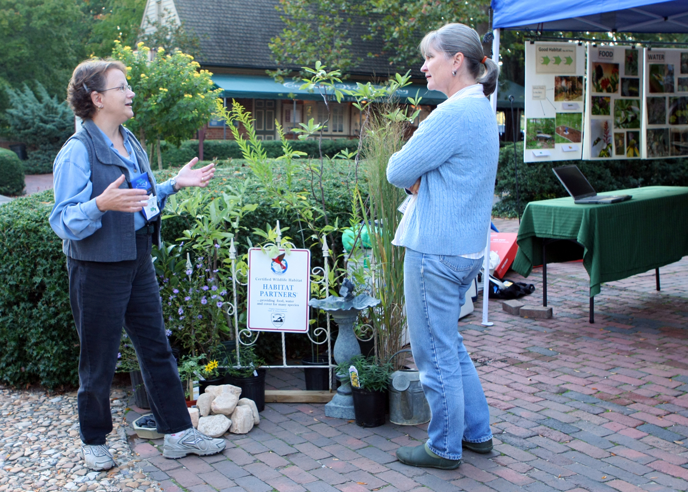 Two women talking in front of a landscaping display