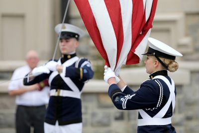 Members of the Corps of Cadets color guard lower the American flag.