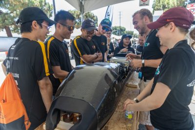 The Virginia Tech Hyperloop team discusses their pod with engineers from competing teams.
