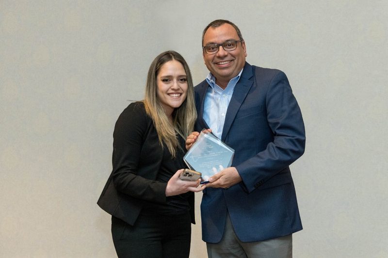 First-year DVM student Estefania Pereyra (at left) presents Roger Ramirez-Barrios with the award.