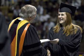 President Steger presents a diploma to a graduate.