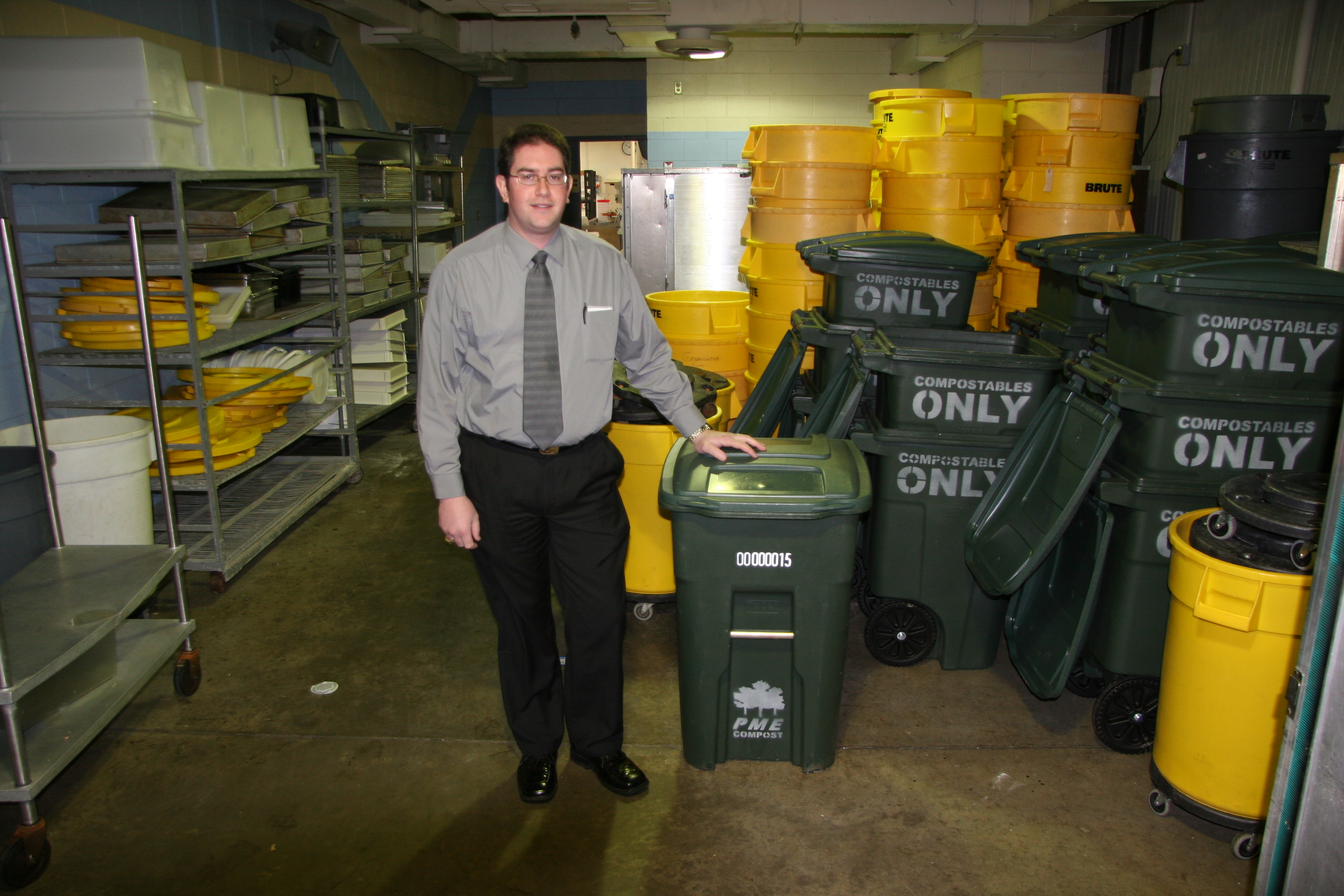 Steve Garnett, the unit manager for the Southgate Food Processing Center, stands next to a 48-gallon container used to collect food waste.