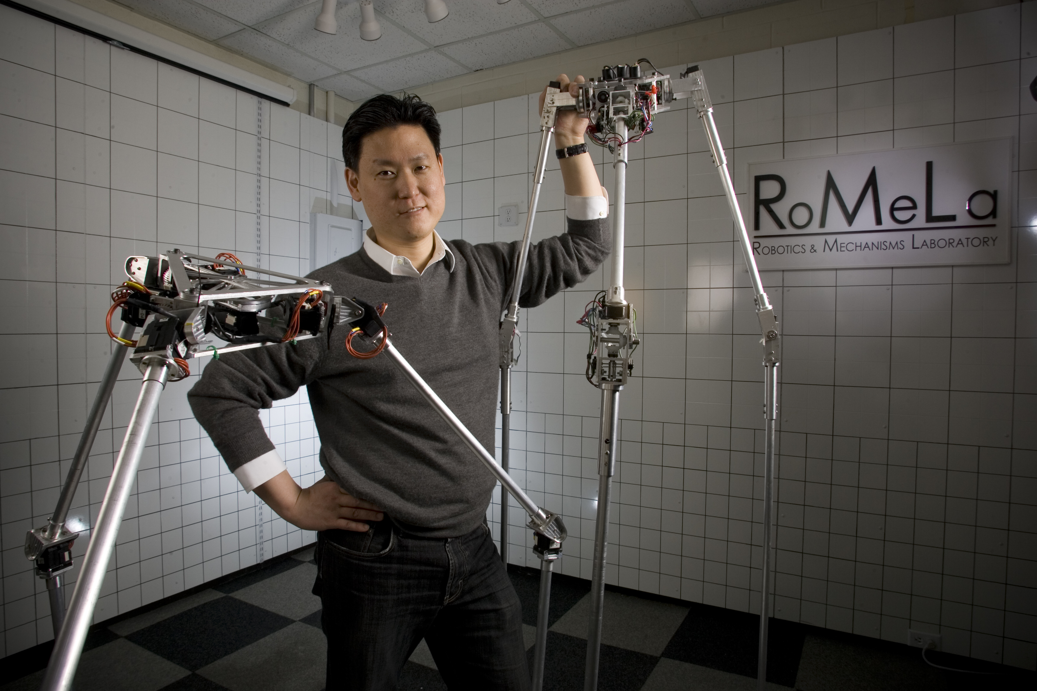 Dennis Hong stands with one of his robot creations, STriDER.