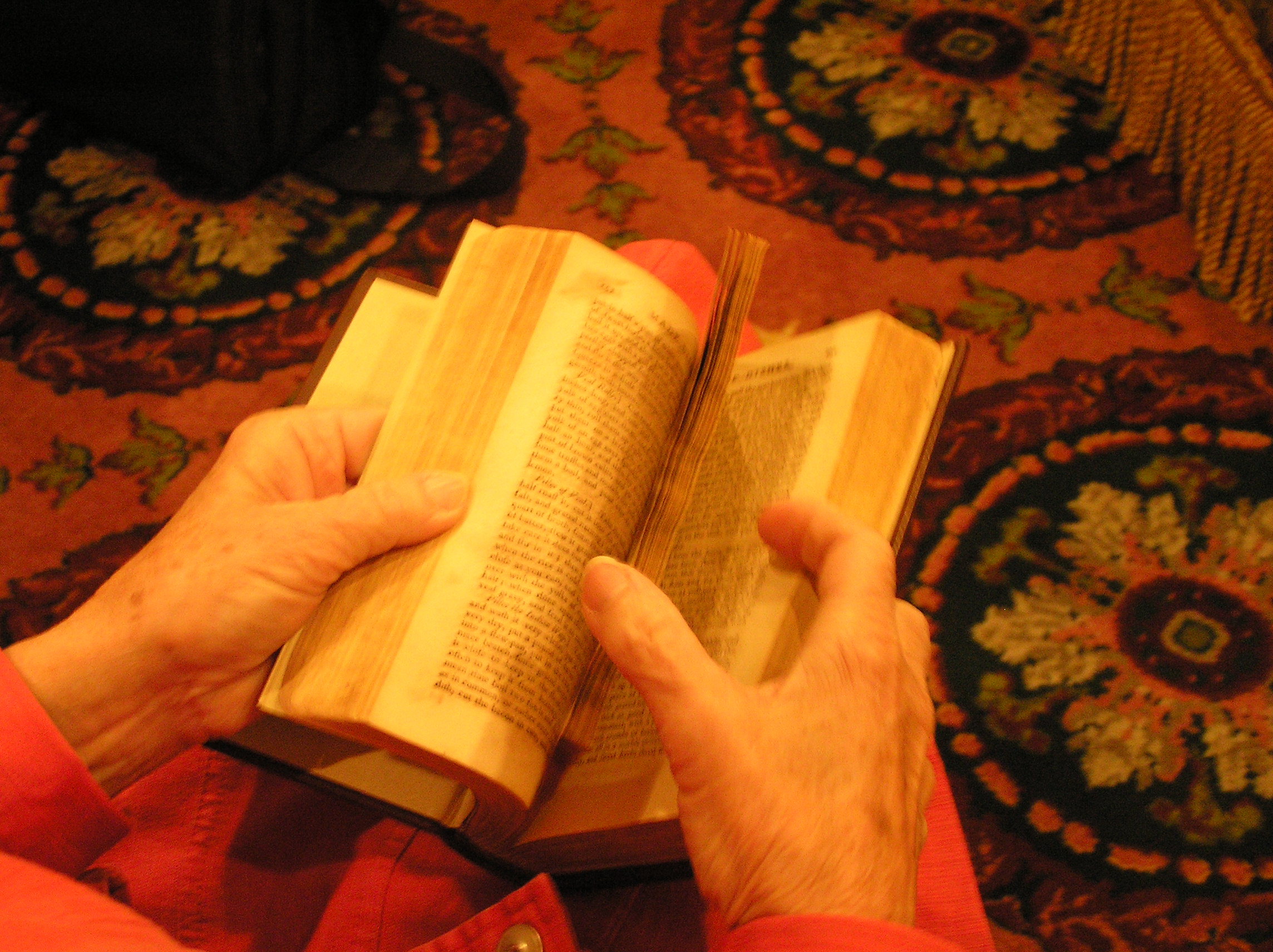 A member of the Peacock-Harper Friends holds a copy of <cite>The New Art of Cookery</cite> by Richard Briggs, published in 1798. This volume was added as the 3 millionth barcoded item in Virginia Tech's library collections in 2007.