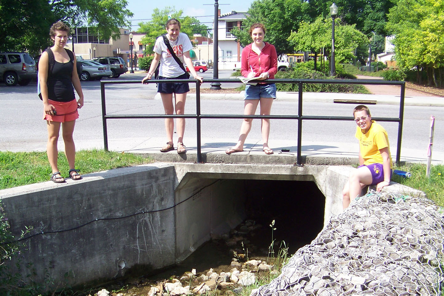 Student researchers gather at a storm drain that leads to Stroubles Creek.