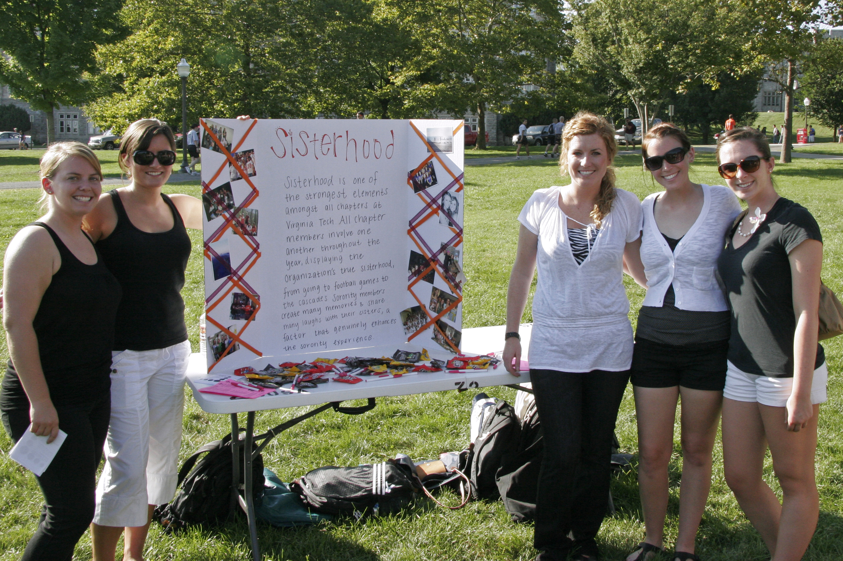 Five sorority women stand on the Drillfield with a sisterhood display.