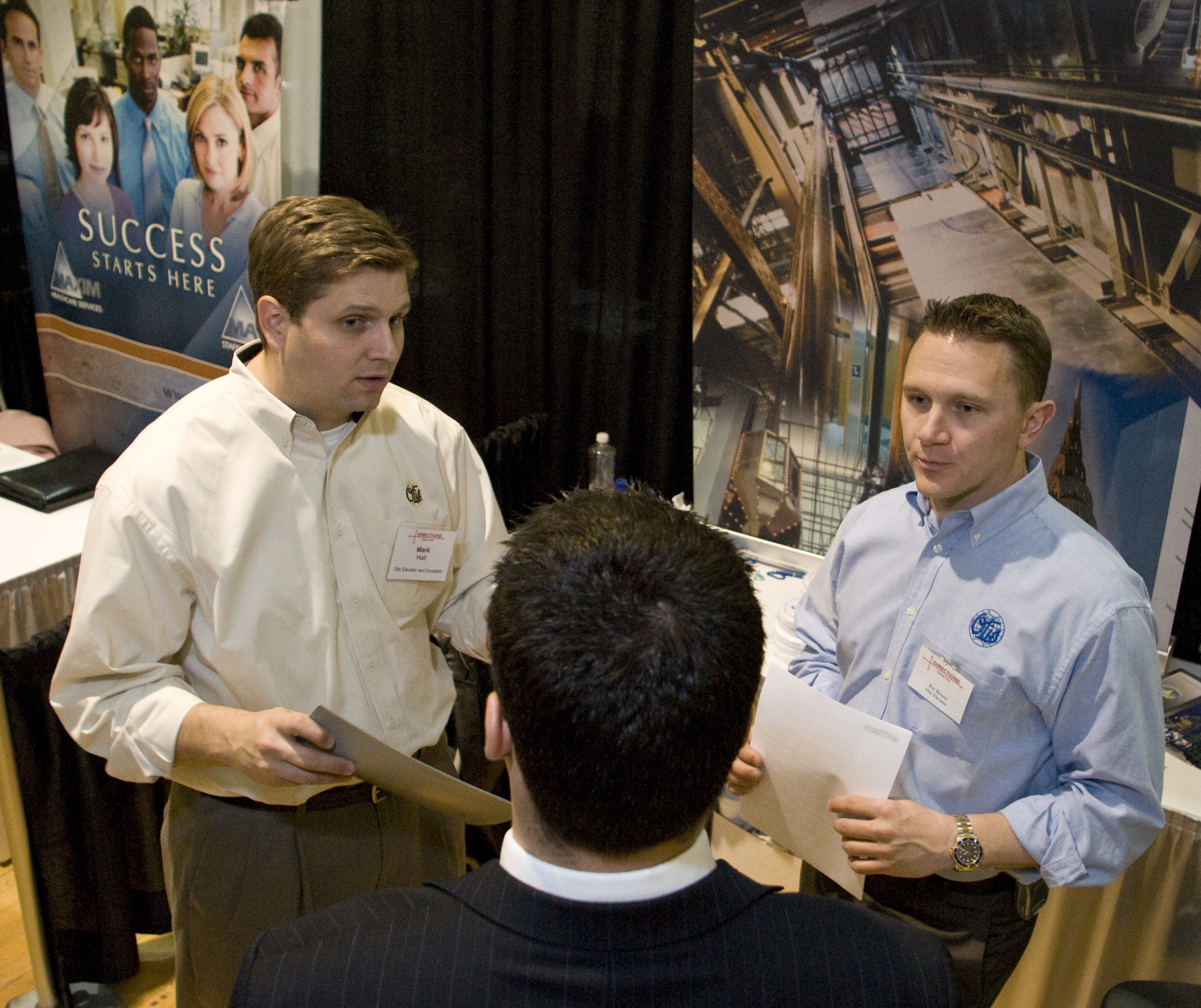 Employers talk with student at job fair.