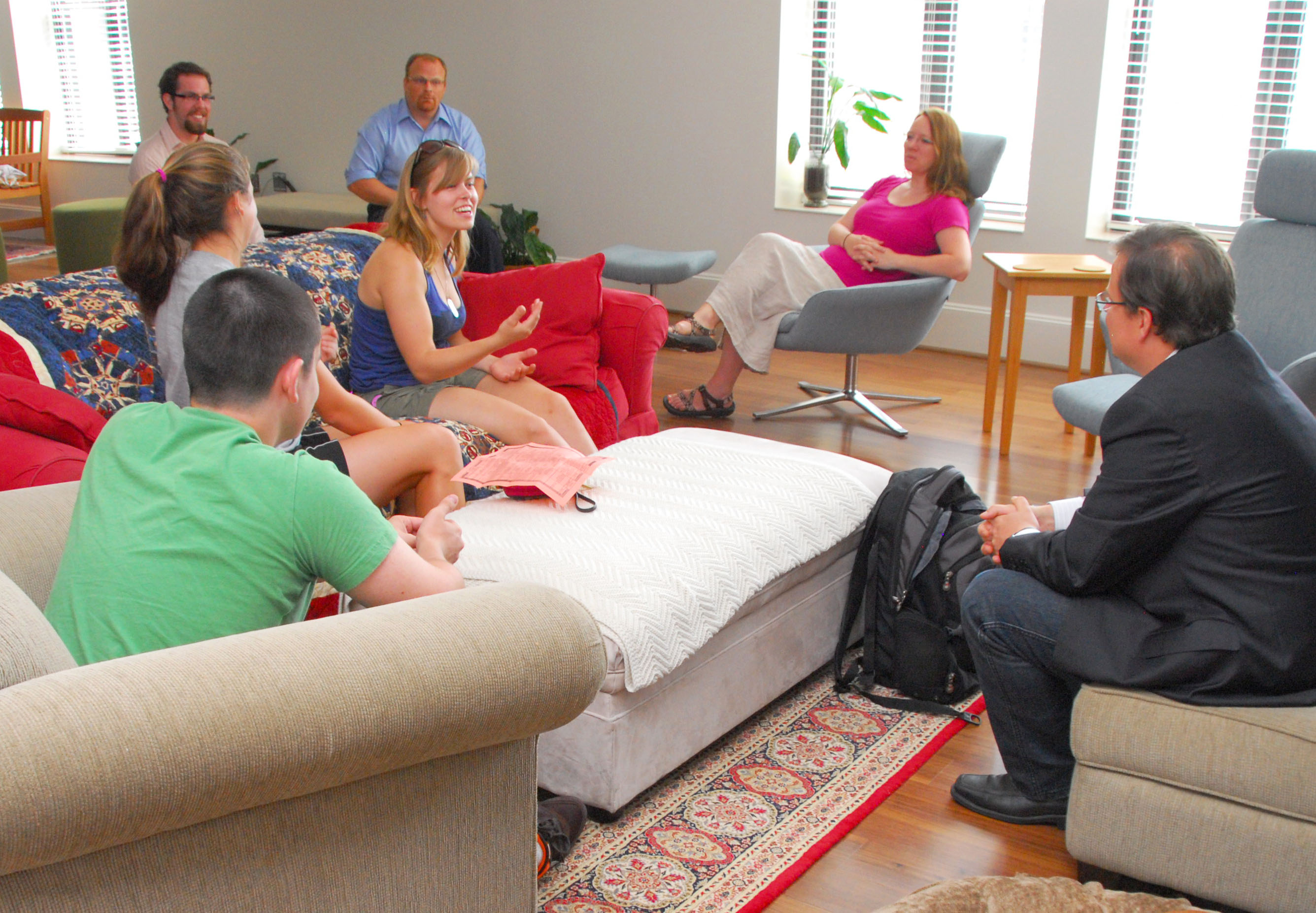 Students, faculty, and faculty principals talk in the sitting room at the Honors Residential College.