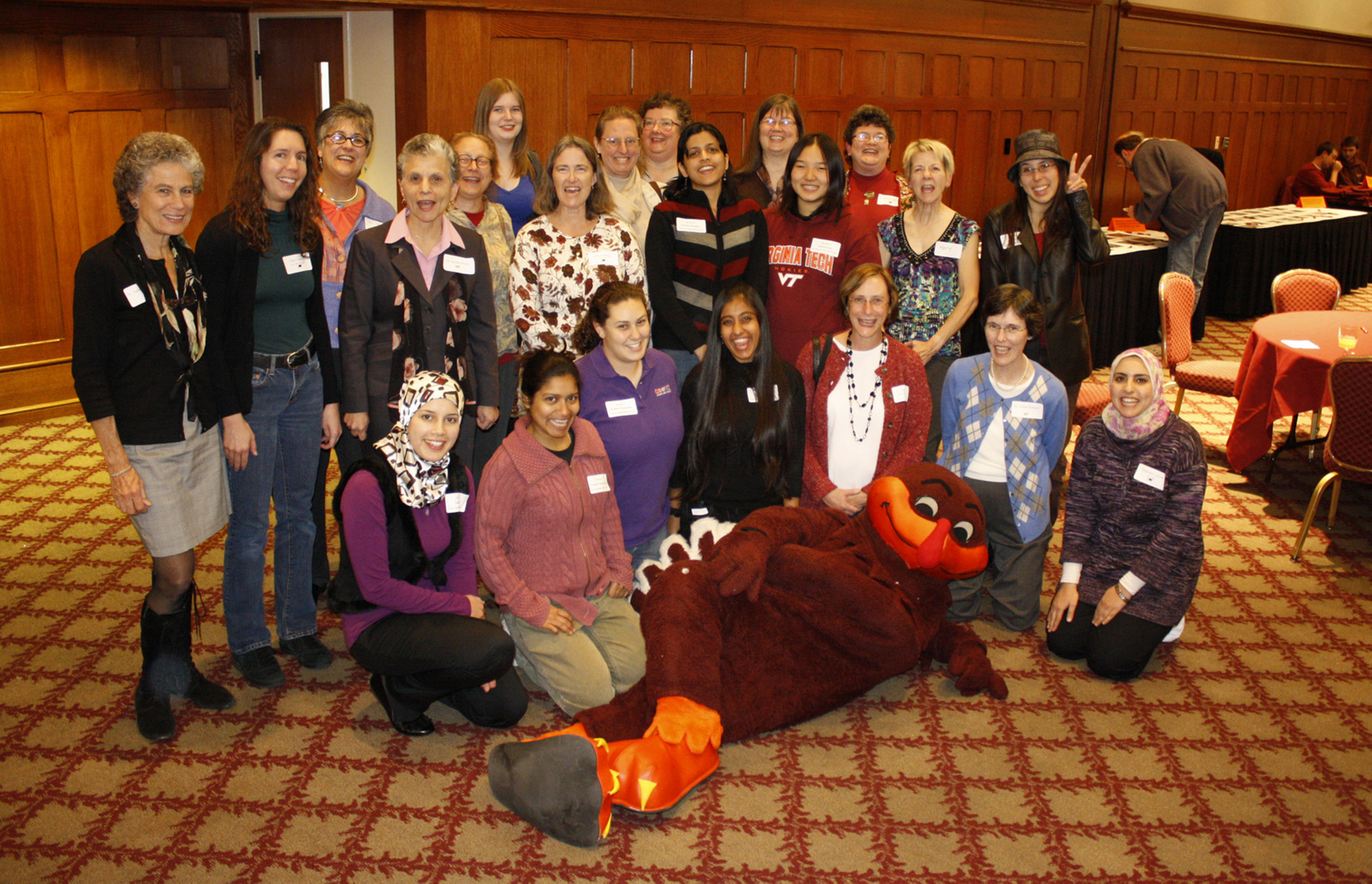 Computer science female students and graduates with Hokie bird