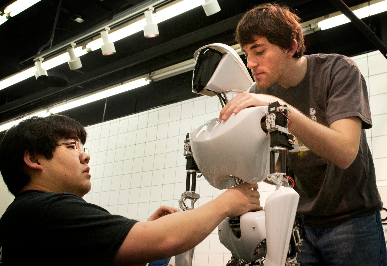 (Left to right) Mechanical engineering doctoral student Bryce Lee and mechanical engineering master's student Coleman Knabe work on CHARLI 2, a soccer-playing humanoid robot built in the Robotics and Mechanisms Laboratory, part of the College of Engineering. 