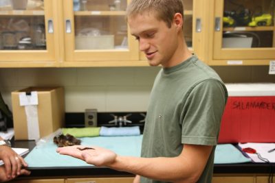 Student Tyler Williams holds a salamander.