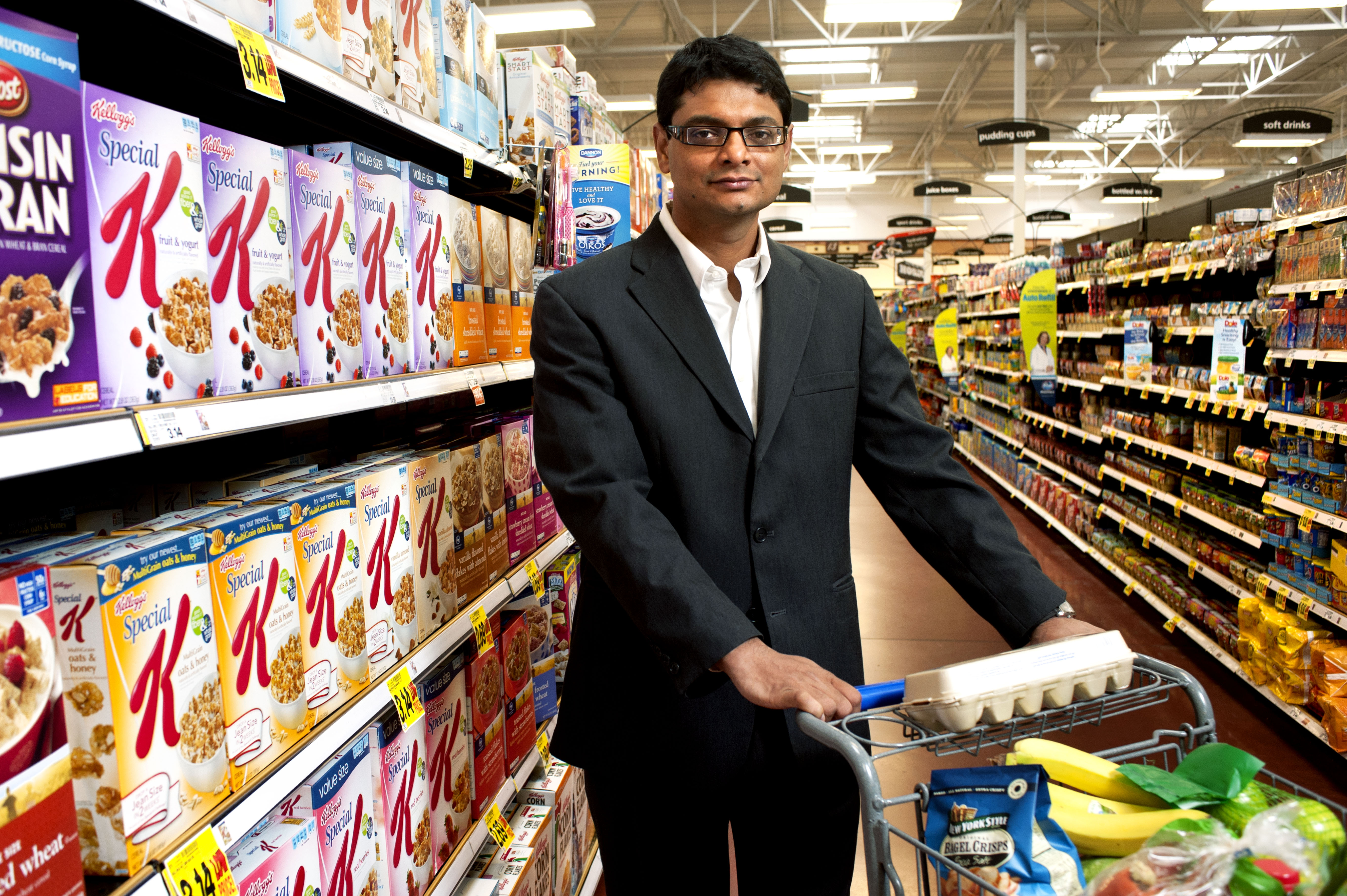 Marketing associate professor and consumer behavior researcher Rajesh Bagchi stands next to colorful boxes of cereal in a grocery store.