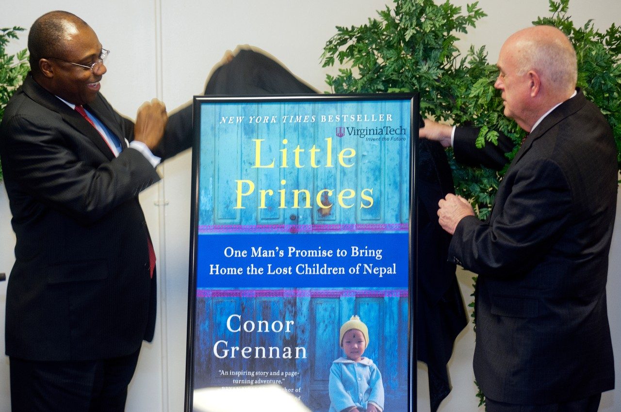Daniel Wubah, vice president for undergraduate education, and Mark McNamee, provost, unveil "Little Princes" as the 2013-14 Common Book during a ceremony on Friday, March 1, 2013.