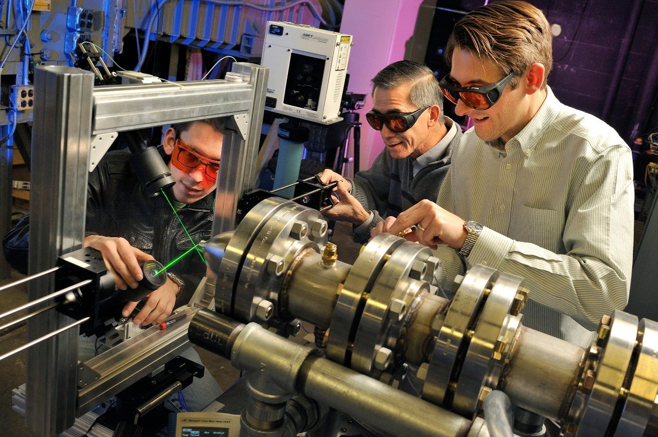Left to right, Tobias Ecker, a doctoral student in the Virginia tech Department of Aerospace and Ocean Engineering; Wing Ng, the Chris Kraft Endowed Professor in the Department of Mechanical Engineering; and said Todd Lowe, an assistant professor in the aerospace and ocean engineering program, work on the model-scale engine inside a Randolph Hall lab.