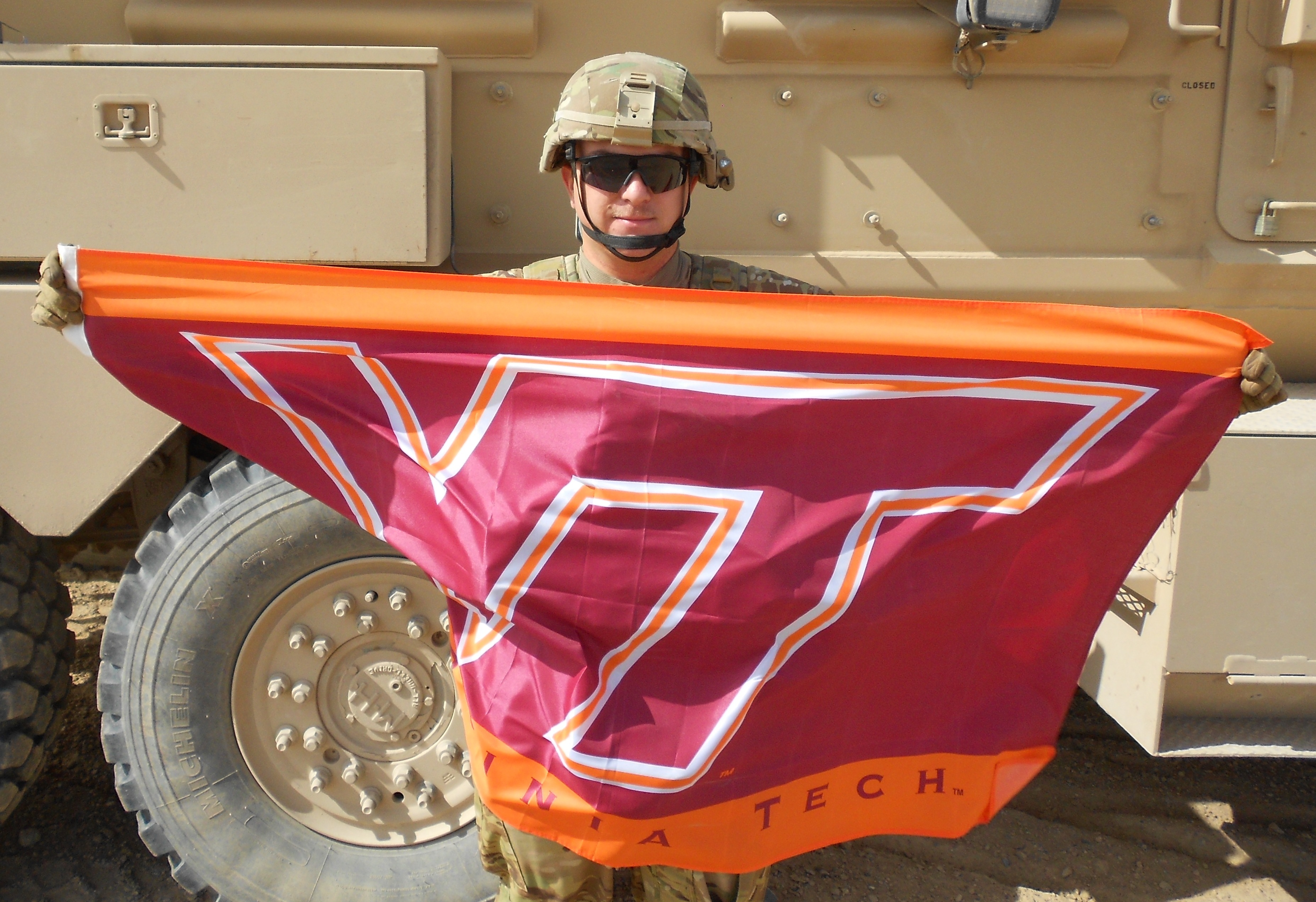 1st Lt. Tracy Porter, U.S. Army, Virginia Tech Corps of Cadets Class of 2010 standing in front of his armored vehicle in Afghanistan