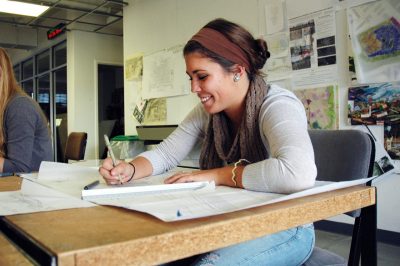 A female student using a pen to draw renderings