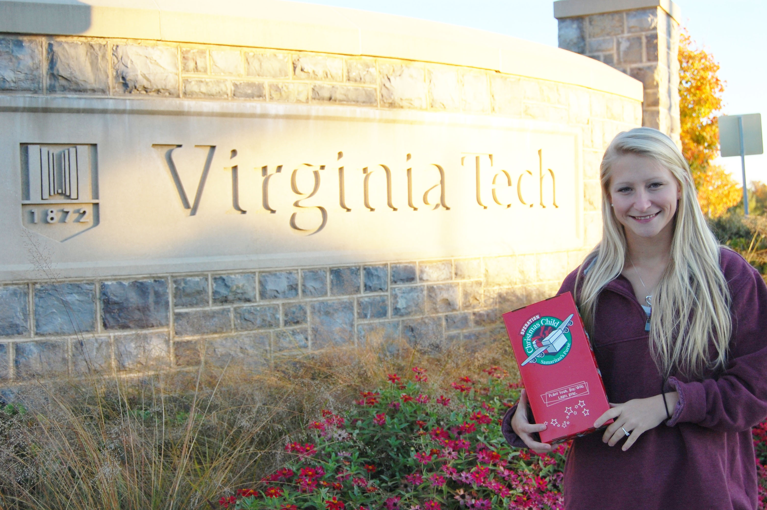 Student stands in front of Virginia Tech entrance sign