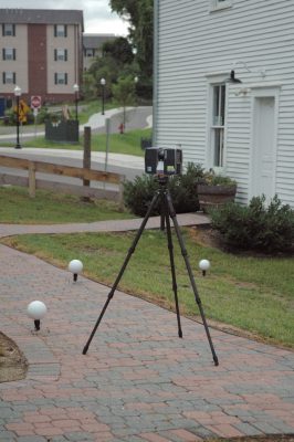 The scanner on a tripod and three spheres are positioned in front of St. Luke and Odd Fellows Hall