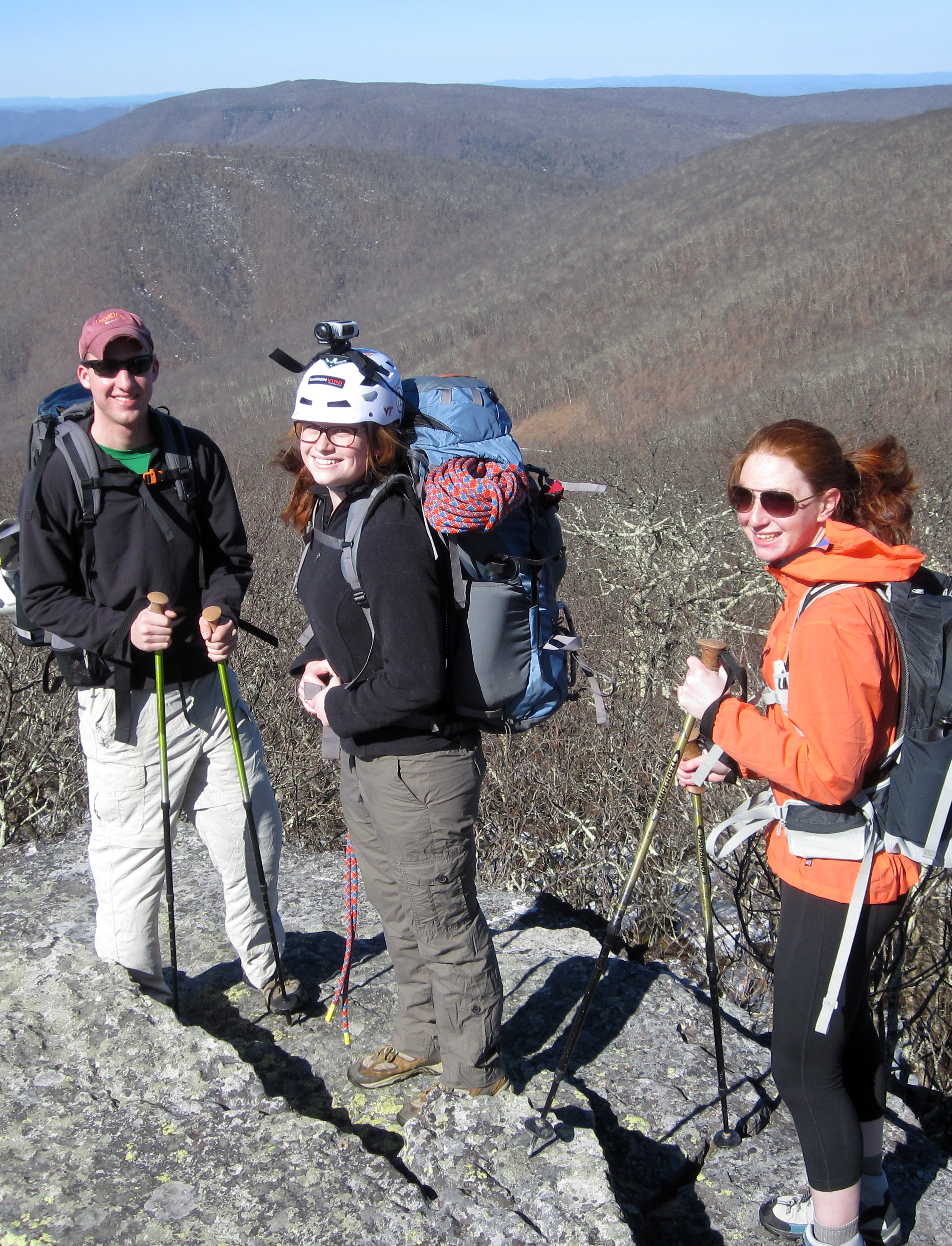 Three students standing on a mountaintop.