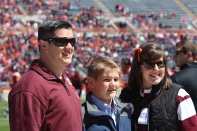 Erin Helbling, right, and her brothers Jacob and Caleb, left to right, enjoyed the presentation of the Family of the Year award at the spring football game. 