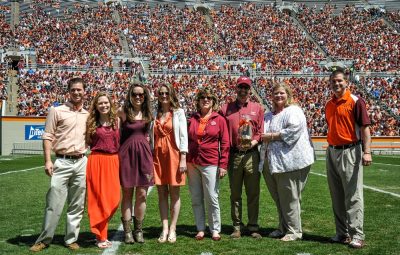 Thomas Clements; Heather Hicks; Mikayla Meyer; Amanda Clements; Faith Hicks; Alan Hicks; Patty Perillo, vice president of Student Affairs; and Rick Sparks, associate dean, New Student and Family Programs stand on the football field