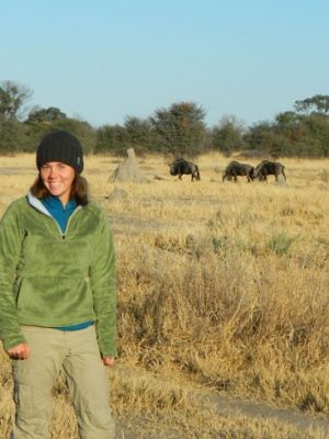 Lindsey Rich on the savannah with wildebeest in the background
