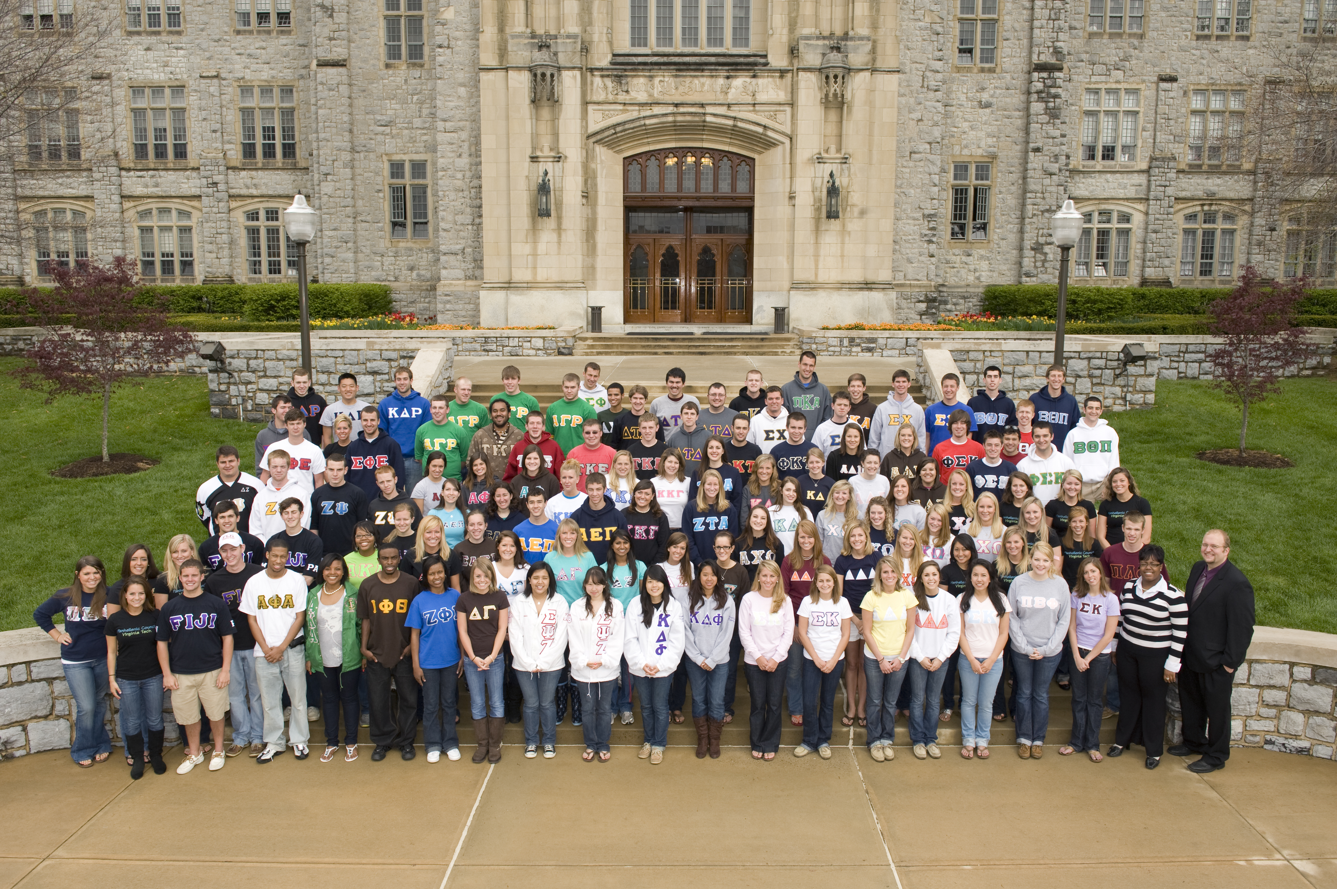Group of fraternity and sorority members gathered on the steps of Burruss Hall