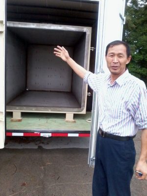 Zhangjing Chen standing in front of an open truck trailer.