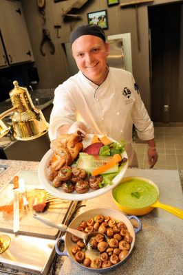 Chef displays plate of locally grown food.