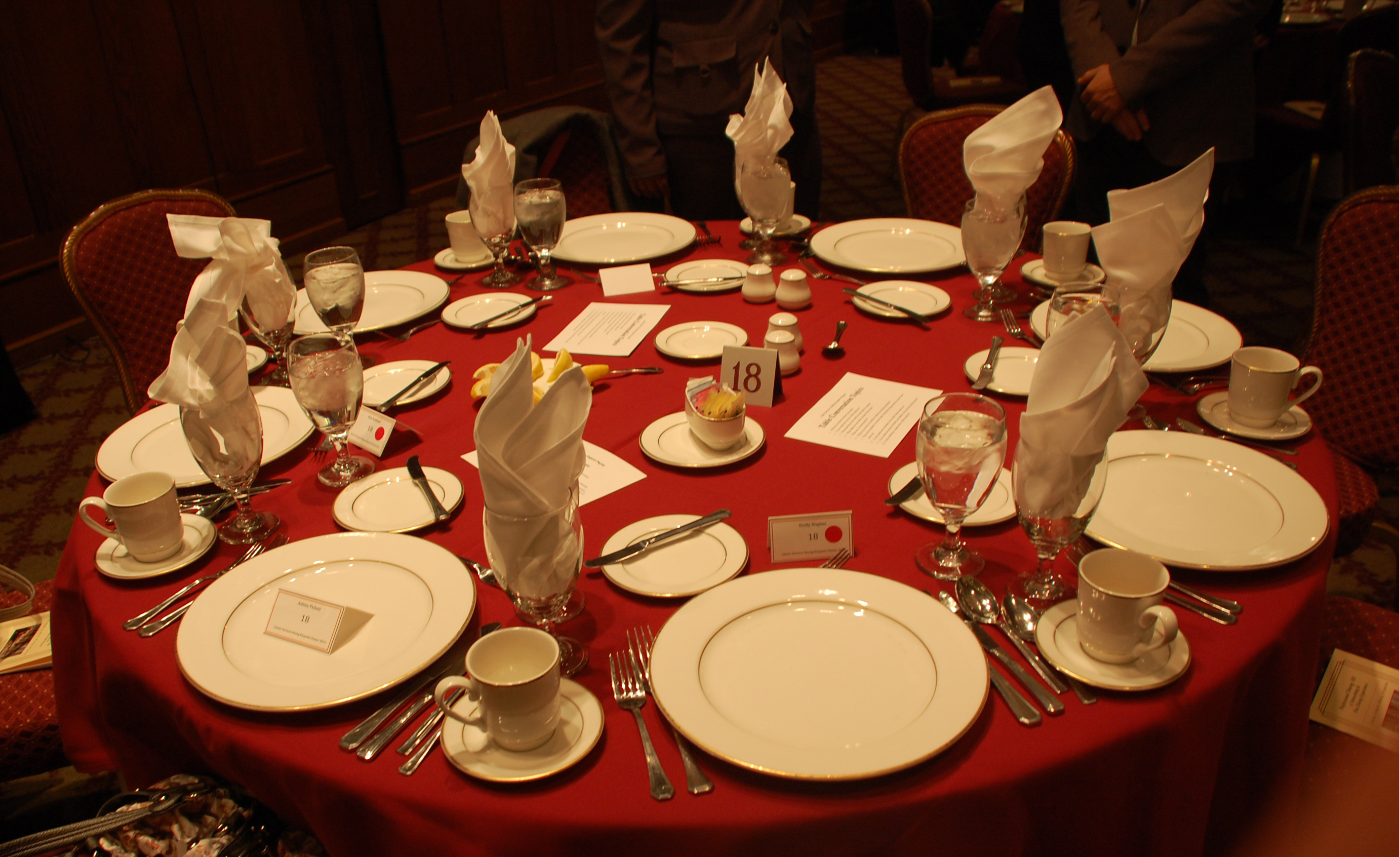 A formal dinner setting on a red tablecloth