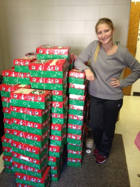 Student with shoeboxes collected, filled, and sent to children in need.
