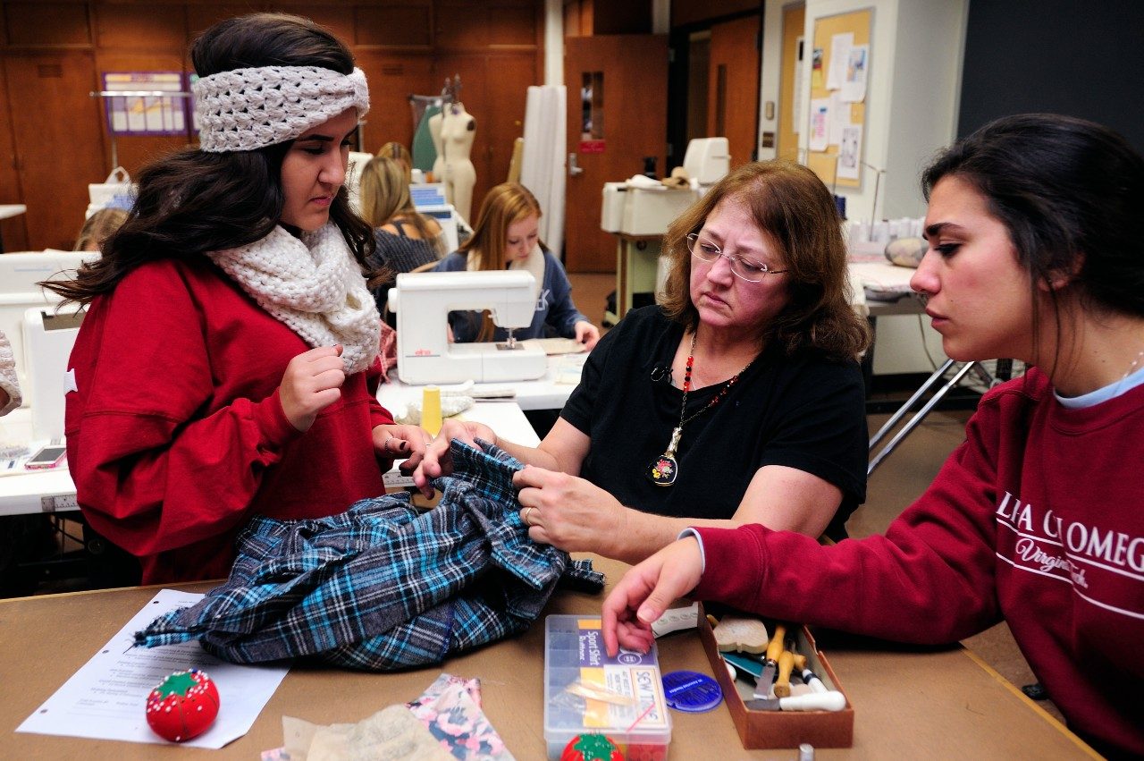 Peggy Quesenberry, center, works with students in an apparel production class.