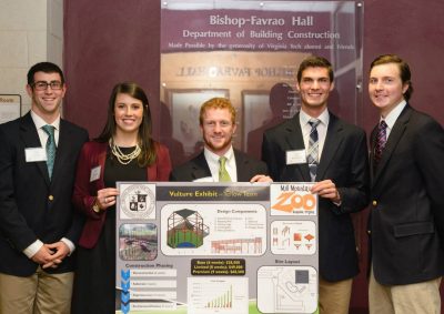 The five students on the team that tied for third place stand with their presentation board.