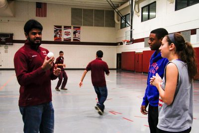 A team member explains the basics of cricket to Virginia Tech students in War Memorial Gym. 