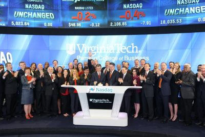 As President Sands and fellow Hokies look on, Dean Sumichrast presses the button to mark the start of the day’s trading at Nasdaq. © 2015, The NASDAQ OMX Group, Inc.