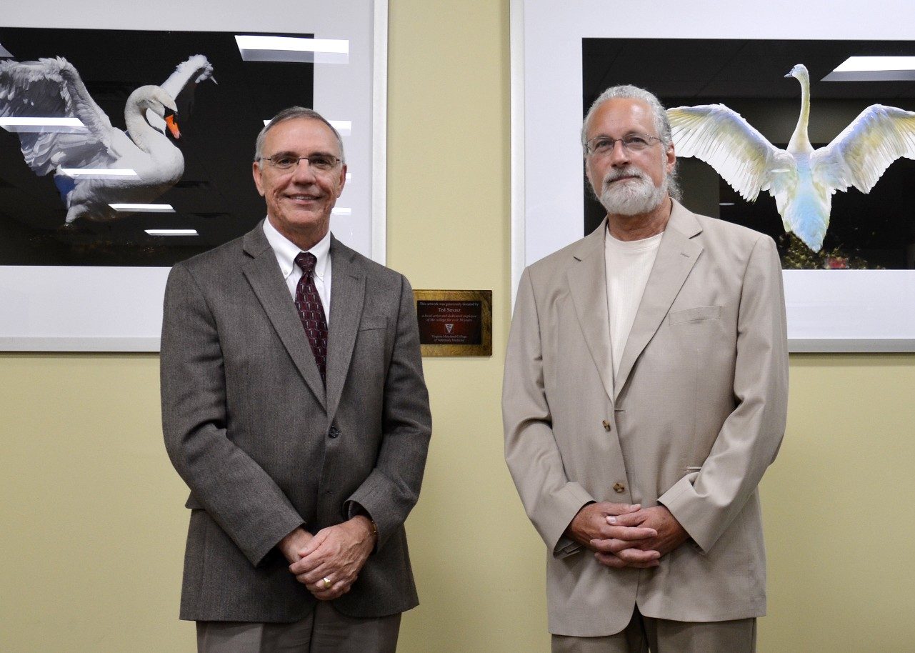 The college recognized Ted Smusz (right), communications assistant, for his art donations with a plaque in the library and student lounge space. Also pictured is Dean Cyril Clarke.