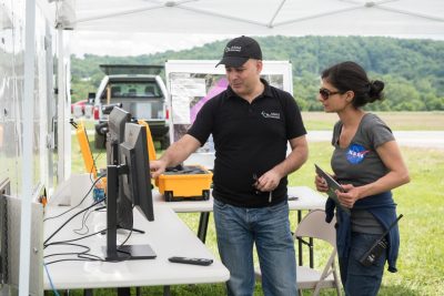 Amit Ganjoo, left, CEO of ANRA Technologies, and Arwa Aweiss, NASA’s Unmanned Traffic Management National Campaign coordinator, watch as the flight paths of unmanned aircraft participating the tests appear on screens displaying a traffic-management software user interface. 