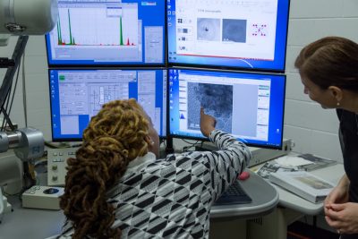 A student attending the HBCU/MSI Research Summit points to a screen of what she sees using the Transmission electron microscope in the Institute for Critical Technology and Applied Science (ICTAS) Nanoscale Characterization and Fabrication Laboratory.