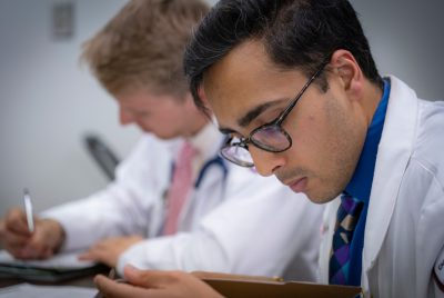 Two medical students writing