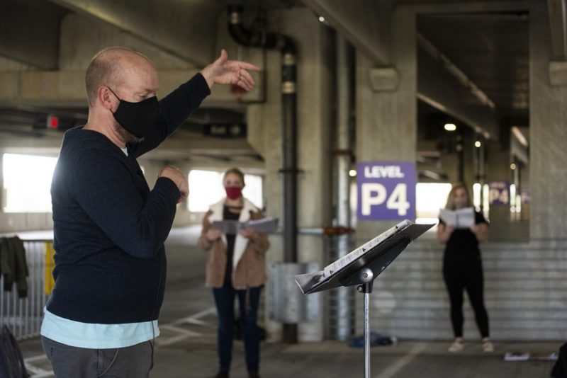 Person leading singing in parking garage 