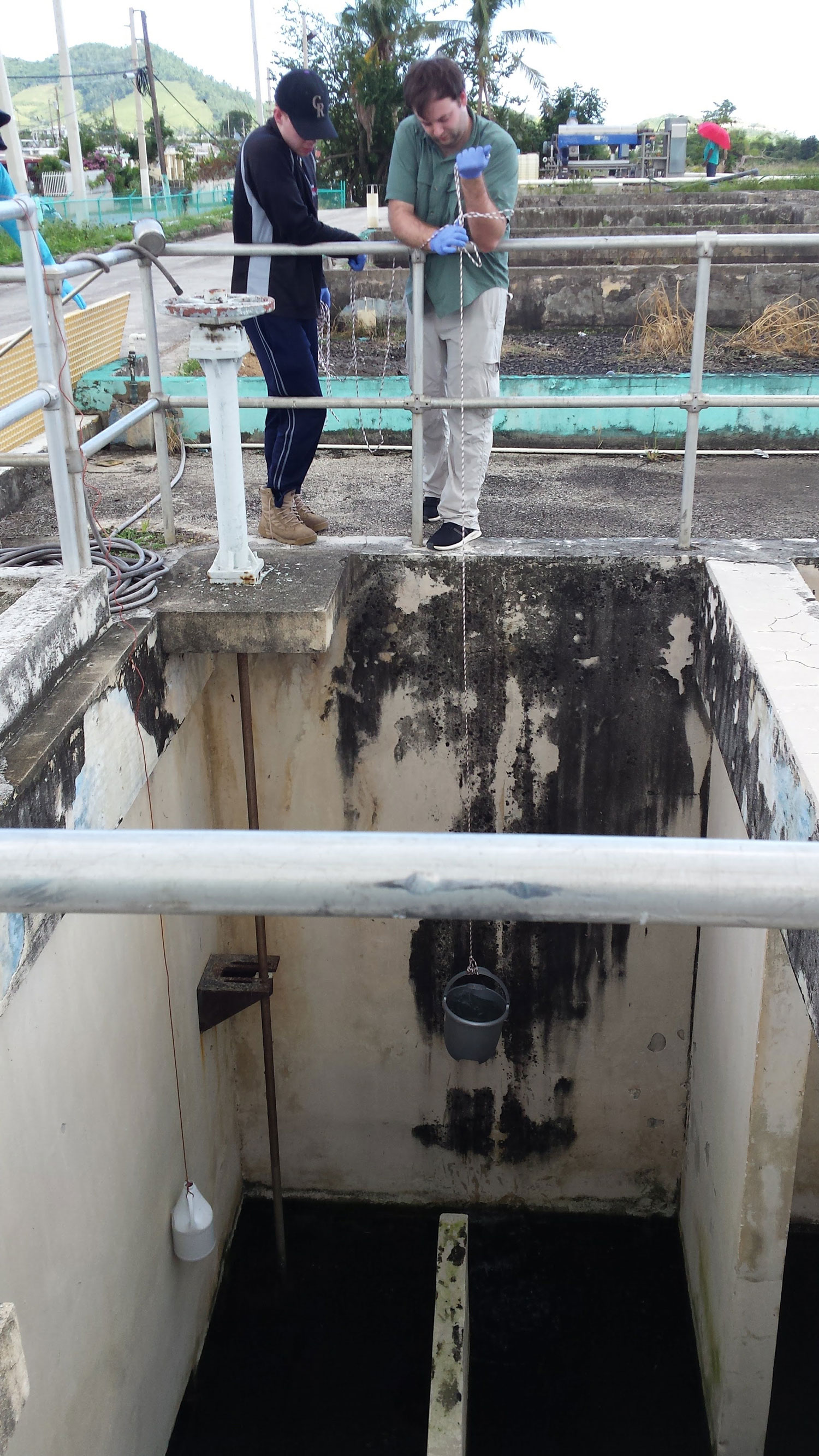 Doctoral students, Benjamin Davis, also first author of the published research, and Matthew Blair, sampling a Puerto Rican wastewater treatment plant.  