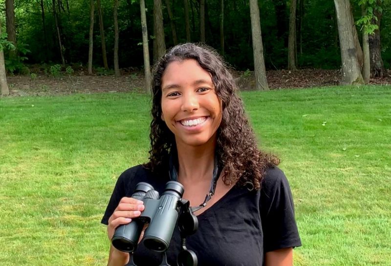 Amber Wendler, a Ph.D. student of Biological Sciences in the College of Science and one of the co-organizers of #BlackBirdersWeek, is smiling while she holds a set of binoculars. 