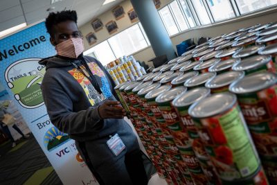 A medical student helps load up a donation bag with canned food